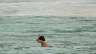 Phuket Adası 'nın güneyindeki Nai Harn plajında genç bir kadın.