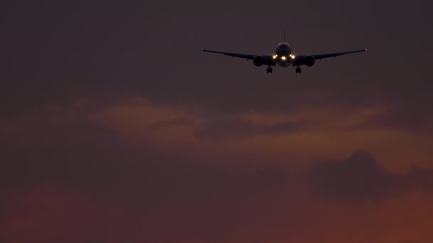 Avion approchant au-dessus de l'océan au coucher du soleil