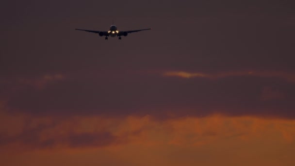 Gün batımında okyanus üzerinden yaklaşan uçak. — Stok video