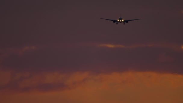 Самолет приближается над океаном на Sunset Backgfround — стоковое видео