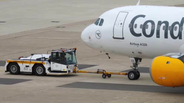 空港のターマックでa320旅客機を押す牽引トラック — ストック動画