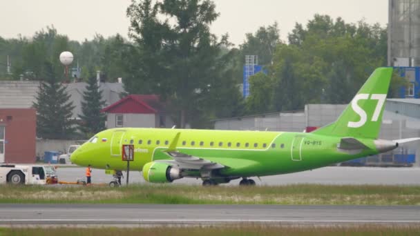 S7 Airlines Embraer 170 bogseras med bogserbåt — Stockvideo