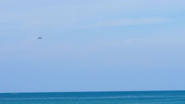 İnişten önce tanımlanamayan bir üniformayla inen bir jet uçağı. Denizin üzerinde uçan uçak. Adanın kıyısında bir havaalanı