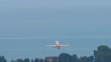 Kalkıştan sonra gökyüzüne yükselen bir jet uçağının uzak dikiz görüntüsü. Yolcu uçağı havacılık ve hava yolculuğunu sembolize ediyor..