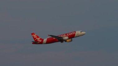 BANGKOK, THAILAND - 16 Mart 2025: Tayland AirAsia Airbus A320, HS-ABZ kalkıştan sonra irtifa kazanıyor ve iniş takımlarını geri çekiyor. Yolcu uçağı kalkıyor