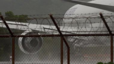 PHUKET, THAILAND - 24 Şubat 2025: Phuket Havaalanı 'nda yağmur sırasında Phuket 767 pistine taksicilik yapan Air Astana' lı Boeing 767, yan görüş. Seyahat kavramı