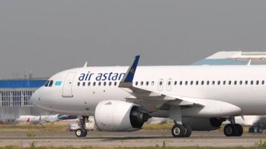 ALMATY, KAZAKHSTAN - 25 Haziran 2025: Air Astana Airbus A320neo, EI-KIB Almaty havaalanında taksicilik. Taksiyoldaki uçak, yan görüş. Uçak kalkıyor. Seyahat kavramı