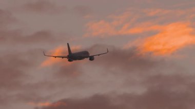 Tanımlanamayan bir uçağın güzel günbatımı gökyüzünde havalandıktan sonra yükseklik kazandığı görüntüler.