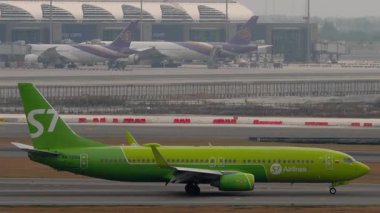 BANGKOK, THAILAND - 17 Mart 2025: S7 Airlines uçağı, Boeing 737 Suvarnabhumi havaalanında taksicilik yapıyor. Pistteki uçak, yan görüş. Seyahat kavramı