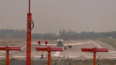 Tanımlanamayan bir üniformanın havalandığı ve irtifa kazandığı bir jet uçağının arka görüntüsü. Seyahat kavramı