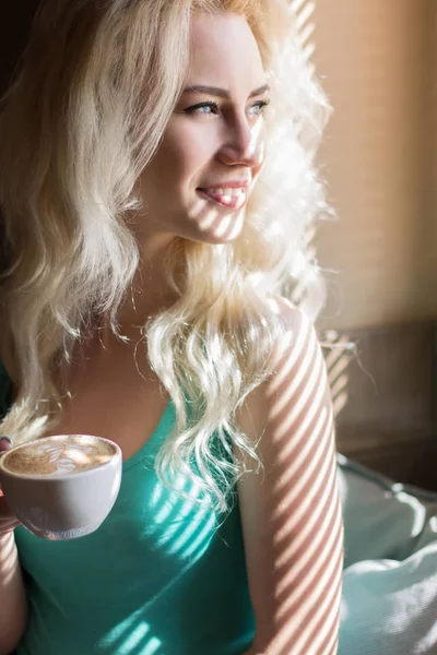 Портрет современной девушки с кофе в свете жалюзи — стоковое фото