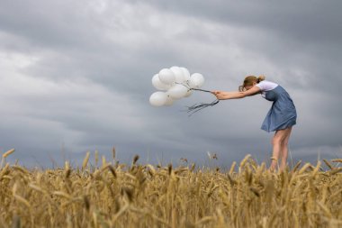 Balonlar içinde kuvvetli rüzgar ile yalnız bir kadın. Kopya alanı