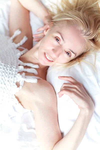 Schöne Frau in weißen Dessous erwacht im Schlafzimmer. — Stockfoto