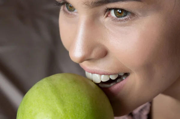 Beautiful Woman Bites Green Apple. Perfect Teeth. Dentistry