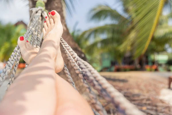 Frau, die in einer Hängematte auf tropischem Hintergrund ruht. Meer und Ruhe. Reise. Urlaub — Stockfoto