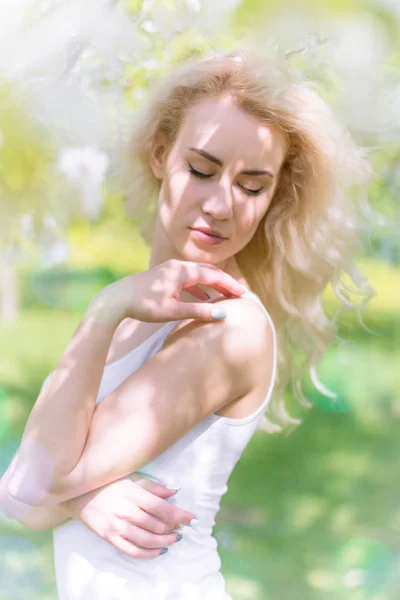 Красивая блондинка наслаждается в цветущем саду — стоковое фото