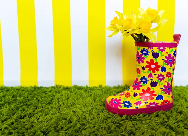 Bright Baby Boots with Spring Yellow Flowers. Background