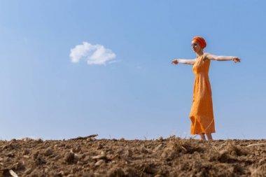 Türbanlı Etnik Kadın Gökyüzünde Temiz Toprakta Dans Ediyor ve Bulutlar Arka Planda