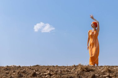 Türbanlı Etnik Kadın Gökyüzünde Temiz Toprakta Dans Ediyor ve Bulutlar Arka Planda