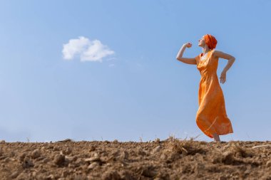 Türbanlı Etnik Kadın Gökyüzünde Temiz Toprakta Dans Ediyor ve Bulutlar Arka Planda