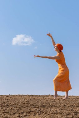Türbanlı Etnik Kadın Gökyüzünde Temiz Toprakta Dans Ediyor ve Bulutlar Arka Planda