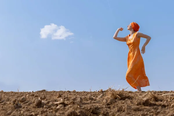 Mulher étnica em turbante dança em solo limpo no céu e nuvens fundo — Fotografia de Stock