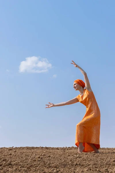 Mulher étnica em turbante dança em solo limpo no céu e nuvens fundo — Fotografia de Stock