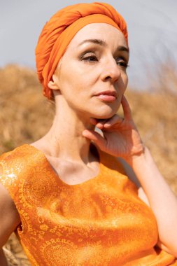 Oryantal Elbiseli Zarif Kadın ve Kuru Çimende Türban