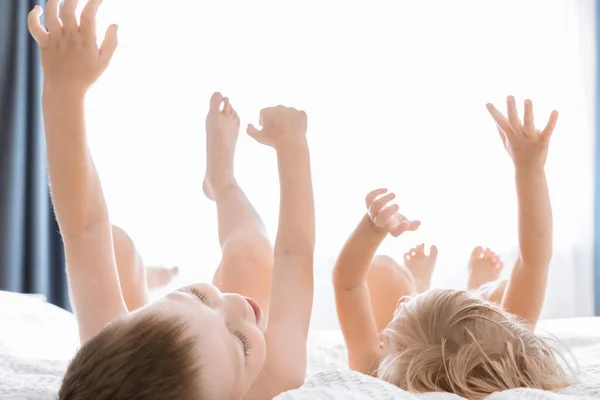 Lindo chico y chica en la cama blanca. Concepto Infantil. Hermano y hermana — Foto de Stock