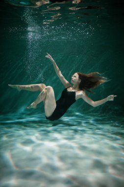 Genç Slender Kız bir bezle suyun altında. Su Büyüsü. Su altı fotoğrafçılığı. Sanat