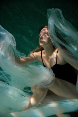 Genç Slender Kız bir bezle suyun altında. Su Büyüsü. Su altı fotoğrafçılığı. Sanat