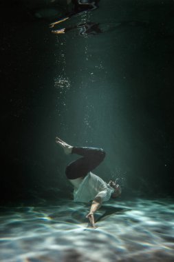 Suyun altındaki adam sıradan giyiniyor. Boşluğu Kopyala
