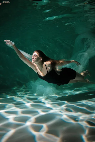 Jeune fille mince sous l'eau avec un chiffon. Magie de l'eau. Photographie sous-marine. L'art — Photo