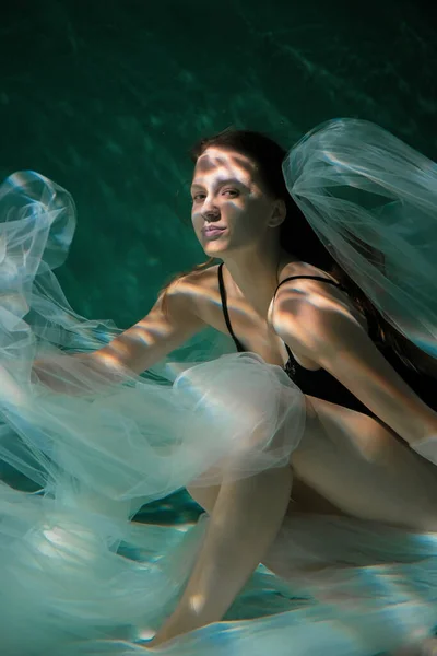 Jeune fille mince sous l'eau avec un chiffon. Magie de l'eau. Photographie sous-marine. L'art — Photo