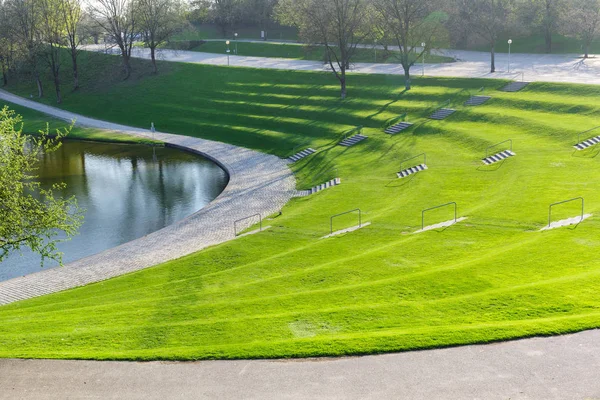 Spring city park with green terrace lawn and staircase