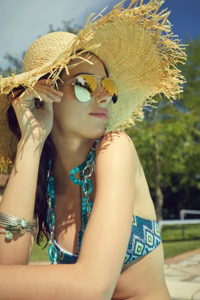 比基尼泳装在游泳池里的气垫上晒日光浴的女人 — 图库照片