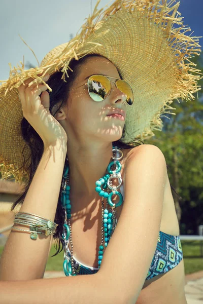 Güneş şapka şişme yüzme havuzunda güneş banyosu içinde güzel kadın