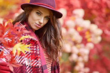 Sonbaharda parkta duran zarif bir kadın. 