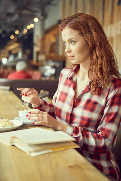 咖啡馆里的女孩正在喝咖啡和看书 — 图库照片
