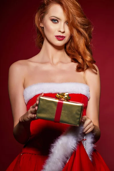 クリスマス プレゼントとサンタ クロースの服を着て美しいセクシーな女の子 — ストック写真