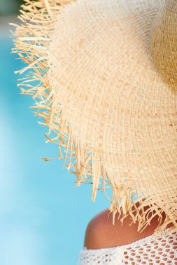 Havuz yanında oturan ve onun omuz üzerinden gülümseyen bir kadın görüntüsü