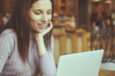 Güzel esmer kafede dizüstü bilgisayar kullanarak. Blogger iş kavramı