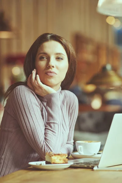 Beautiful brunette using laptop in cafe. Blogger work concept