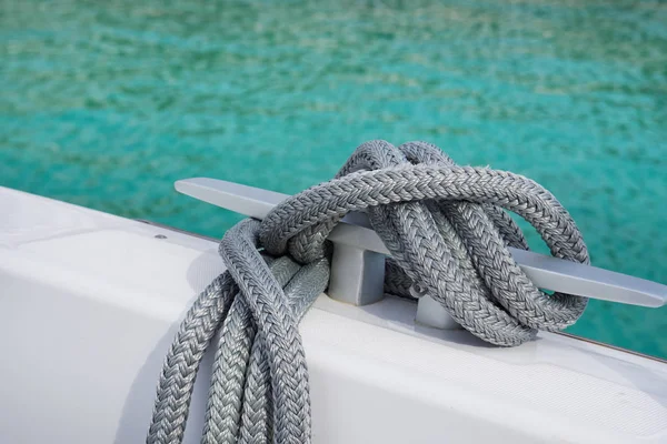 Coiled rope tied the knot on Edge of the boat .Light background tablets Reflections on the sea.