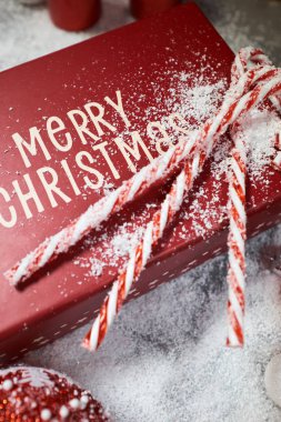 Noel hediye kutusu, şeker kamışı ve köknar ağacı dalı kar masada 