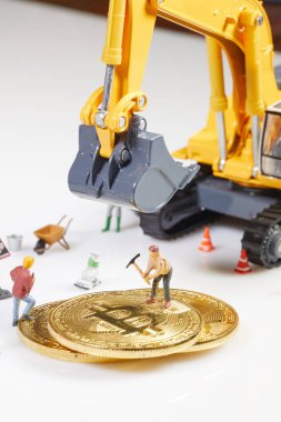 Küçük bir madenci altın sikke ile grafik kartı eşeliyor. Bitcoin madenciliği ve kripto para birimi kavramı. 