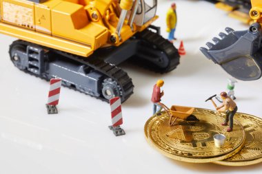 Küçük bir madenci altın sikke ile grafik kartı eşeliyor. Bitcoin madenciliği ve kripto para birimi kavramı. 
