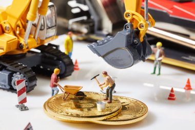 Küçük bir madenci altın sikke ile grafik kartı eşeliyor. Bitcoin madenciliği ve kripto para birimi kavramı. 