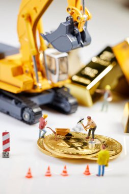 Küçük bir madenci altın sikke ile grafik kartı eşeliyor. Bitcoin madenciliği ve kripto para birimi kavramı. 