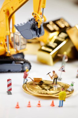 Küçük bir madenci altın sikke ile grafik kartı eşeliyor. Bitcoin madenciliği ve kripto para birimi kavramı. 